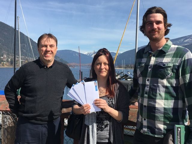 Leanna Hanson-McCormick holds the grand prize of four tickets to zipline-paradise after winning The Nelson Daily Facebook contest. Todd Manton (right) of Kokanee Mountain Zipline and Bruce Fuhr of The Nelson Daily.com made the presentation to Hanson-McCormick. — The Nelson Daily photo